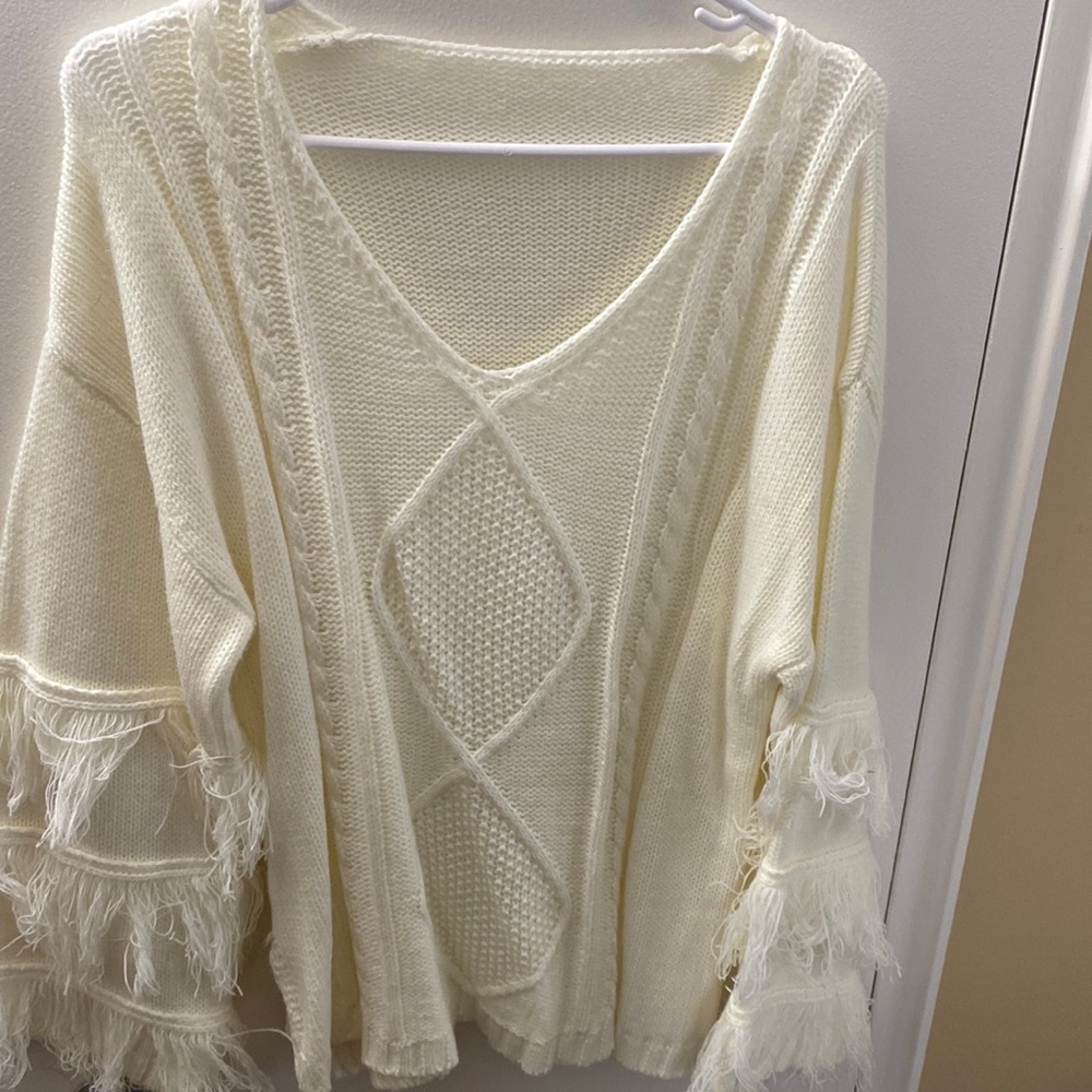 Cable knit sweater with fringe sleeves